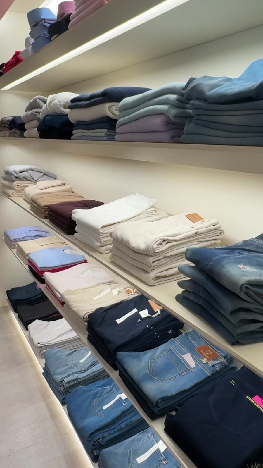 Shelves of folded knitwear and denim