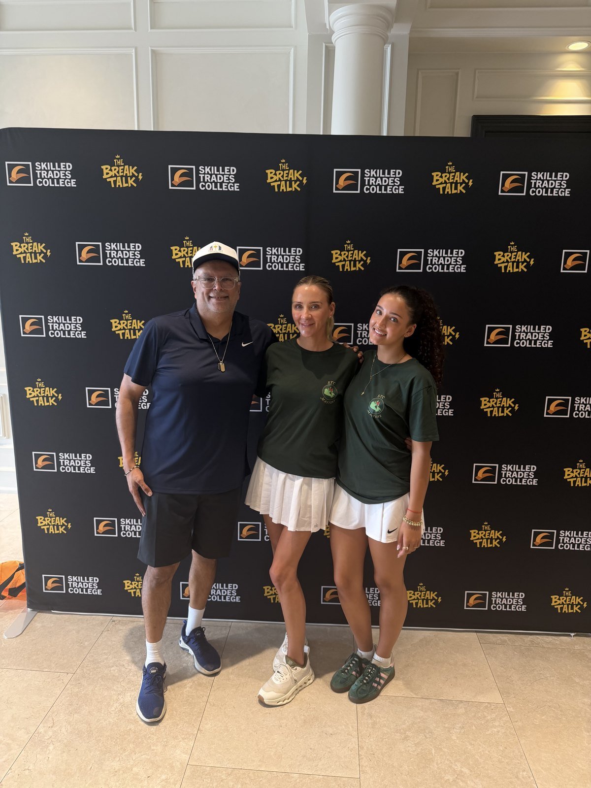 Two foundation supporters with a guest at the event&rsquo;s photo wall